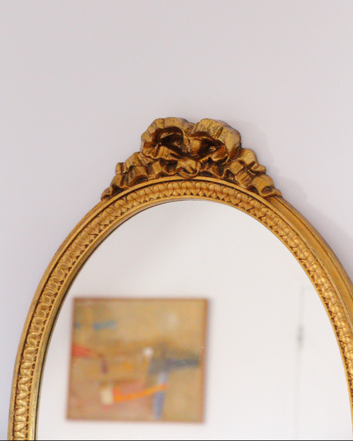 Miroir ovale doré, noeud romantique