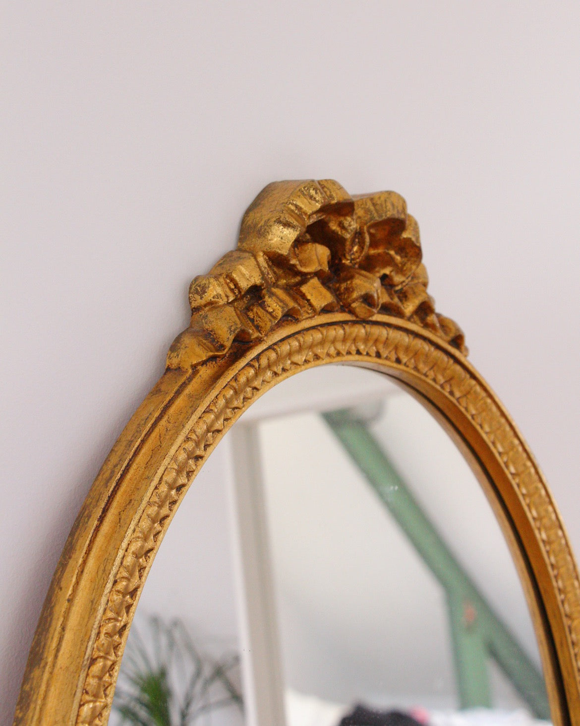 Miroir ovale doré, noeud romantique